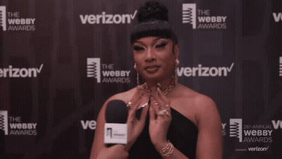 A Woman In Front Of A Wall That Says Verizon On It GIF