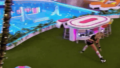 A Woman In High Heels Stands In Front Of A Large Oval Table That Says O On It GIF