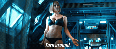 A Woman In Lingerie Is Standing In A Room With The Words Turn Around Behind Her GIF