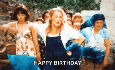 A Woman In Overalls Is Dancing In Front Of A Group Of People And The Words `` Happy Birthday '' Are Written Below Her . GIF