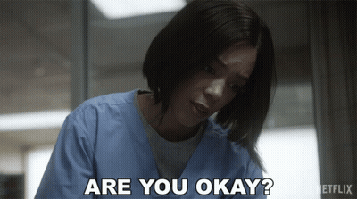 A Woman In Scrubs Is Asking If She Is Okay GIF
