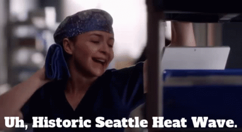 A Woman In Scrubs Is Laughing With The Words Historic Seattle Heat Wave Written Below Her GIF