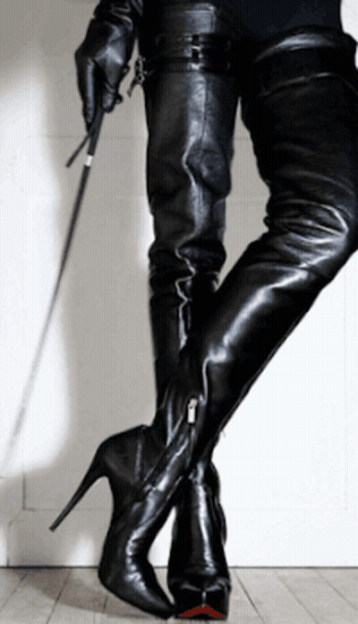 A Woman In Thigh High Boots Holds A Whip In Her Hand GIF