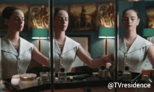 A Woman Is Applying Makeup In Front Of A Mirror With The Hashtag Tvresidence GIF