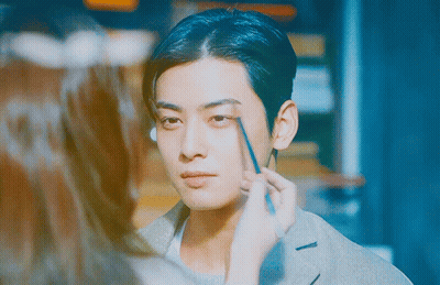 A Woman Is Applying Makeup To A Man 'S Face With A Pencil GIF