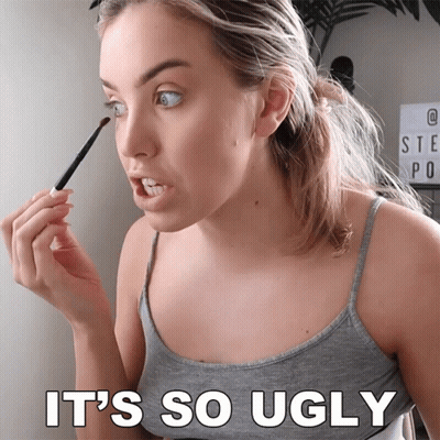 A Woman Is Applying Makeup With The Words It 'S So Ugly Behind Her GIF