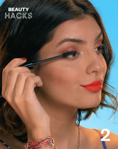A Woman Is Applying Mascara And The Number 2 Is On The Bottom GIF