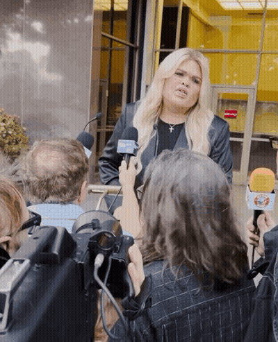 A Woman Is Being Interviewed By A Group Of Reporters Who Are Holding Microphones With The Letters Ctv On Them GIF