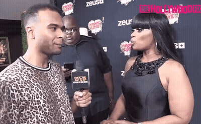 A Woman Is Being Interviewed By A Man With A Microphone That Says Wtb On It GIF