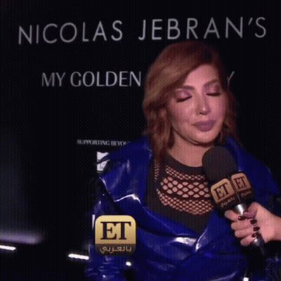 A Woman Is Being Interviewed By A Person Holding A Microphone That Says Et On It GIF
