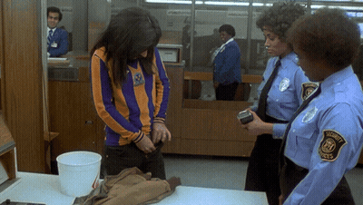 A Woman Is Being Searched By A Security Guard GIF