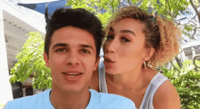 A Woman Is Blowing A Kiss On A Man 'S Face GIF