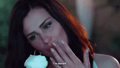 A Woman Is Blowing A Kiss While Holding A White Rose In Her Hand . GIF