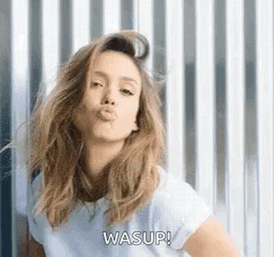 A Woman Is Blowing A Kiss While Wearing A White T-Shirt . GIF