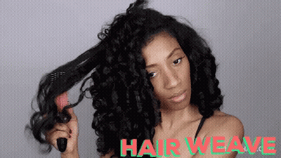 A Woman Is Brushing Her Hair With A Brush And The Words Hair Weave Are Visible Behind Her . GIF
