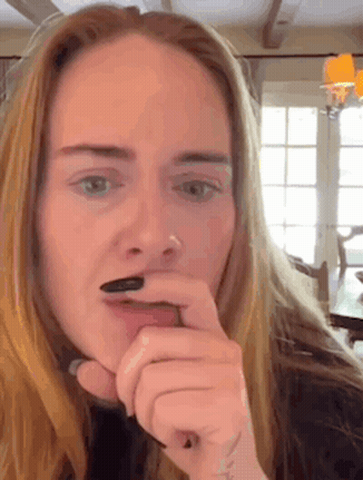A Woman Is Brushing Her Teeth With Her Finger . GIF