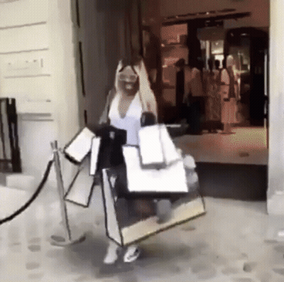 A Woman Is Carrying A Lot Of Shopping Bags In Front Of A Store That Says Gucci GIF