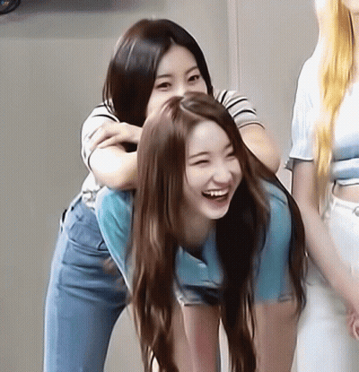 A Woman Is Carrying Another Woman On Her Back And Smiling GIF