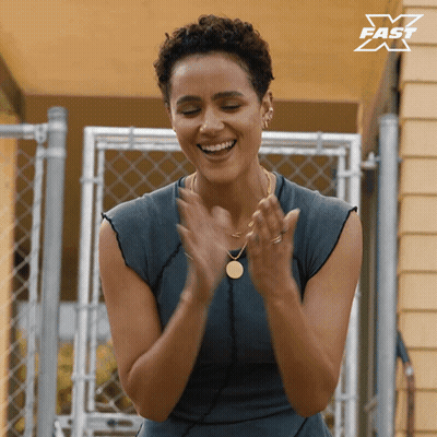 A Woman Is Clapping Her Hands In Front Of A Fence With A X Fast Logo In The Corner GIF