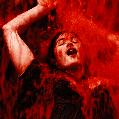 A Woman Is Covered In Red Liquid With Her Mouth Wide Open GIF