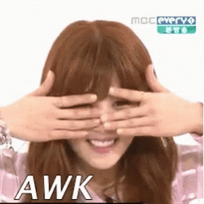 A Woman Is Covering Her Eyes With Her Hands And The Word Awk Is On The Bottom . GIF