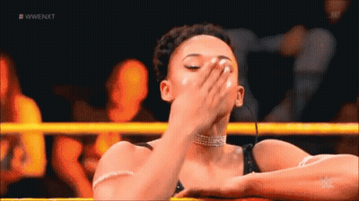 A Woman Is Covering Her Face In A Wrestling Ring . GIF