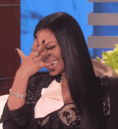 A Woman Is Covering Her Face With Her Hand And Smiling GIF