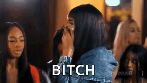 A Woman Is Covering Her Face With Her Hand While A Group Of Women Are Standing Behind Her . GIF