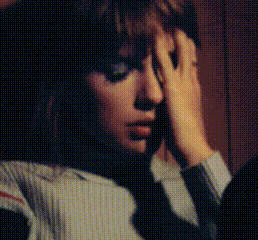 A Woman Is Covering Her Face With Her Hand While Talking On A Phone . GIF