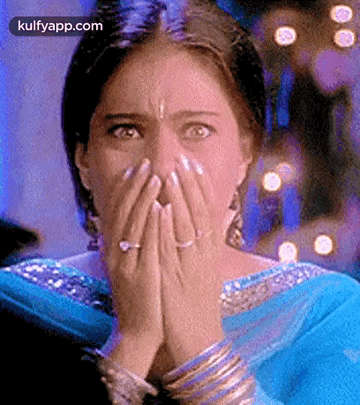 A Woman Is Covering Her Face With Her Hands And A Ring . GIF