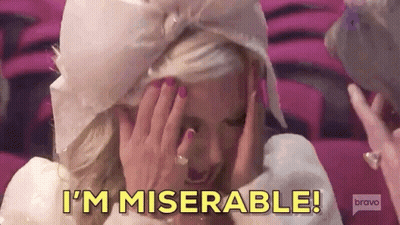 A Woman Is Covering Her Face With Her Hands And Saying I 'M Miserable ! GIF