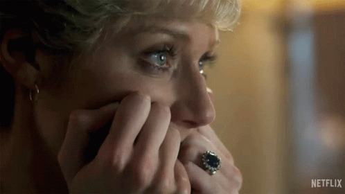 A Woman Is Covering Her Face With Her Hands And Wearing A Ring On Her Finger . GIF