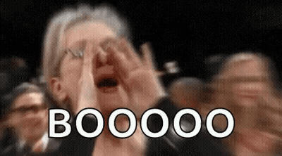 A Woman Is Covering Her Face With Her Hands While A Crowd Of People Applaud . GIF