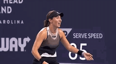 A Woman Is Covering Her Face With Her Hands While Playing Tennis On A Court . GIF
