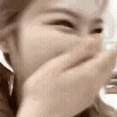 A Woman Is Covering Her Mouth With Her Hand While Laughing . GIF