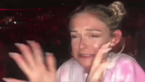 A Woman Is Crying And Covering Her Face With Her Hands While Sitting In A Car . GIF