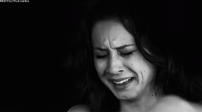 A Woman Is Crying In A Black And White Photo While Covering Her Face With Her Hand . GIF