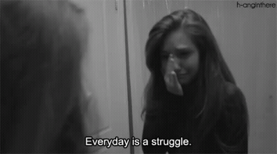 A Woman Is Crying In Front Of A Mirror With The Words " Everyday Is A Struggle " GIF