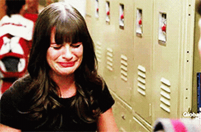 A Woman Is Crying In Front Of A Row Of Lockers GIF