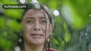 A Woman Is Crying In The Rain And Making A Funny Face . GIF