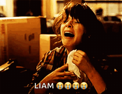 A Woman Is Crying While Holding A Napkin In Front Of A Box That Says ' Liam ' On It GIF