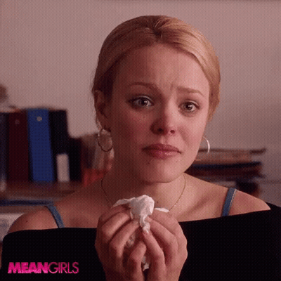 A Woman Is Crying While Holding A Piece Of Paper With The Word Meangirls On The Bottom GIF