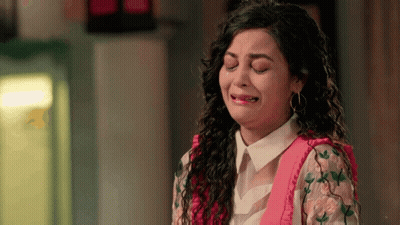 A Woman Is Crying With Her Eyes Closed And A Pink Shirt On GIF