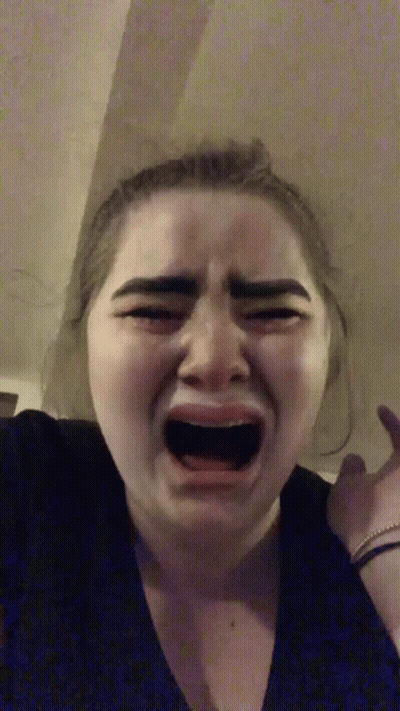 A Woman Is Crying With Her Mouth Open And Making A Funny Face . GIF