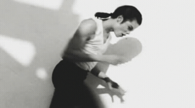 A Woman Is Dancing In A Black And White Photo With Her Arms Outstretched . GIF