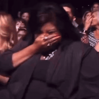 A Woman Is Dancing In A Crowd Of People At A Party . GIF