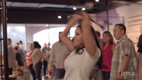 A Woman Is Dancing In A Crowd With A Netflix Logo On The Bottom Right GIF