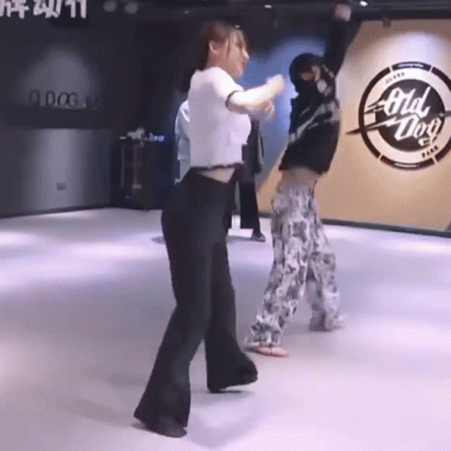 A Woman Is Dancing In A Dance Studio With A Man . GIF