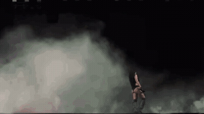 A Woman Is Dancing In A Dark Room With Smoke Coming Out Of The Walls . GIF