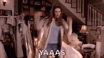 A Woman Is Dancing In A Living Room In Front Of A Staircase In A House . GIF